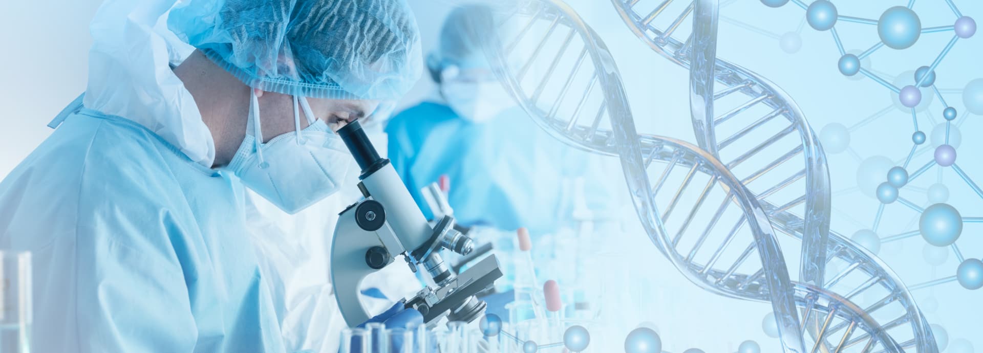 Scientist in scrubs looking at a microscope