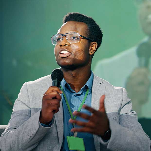 Male Speaker speaking into a microphone on stage