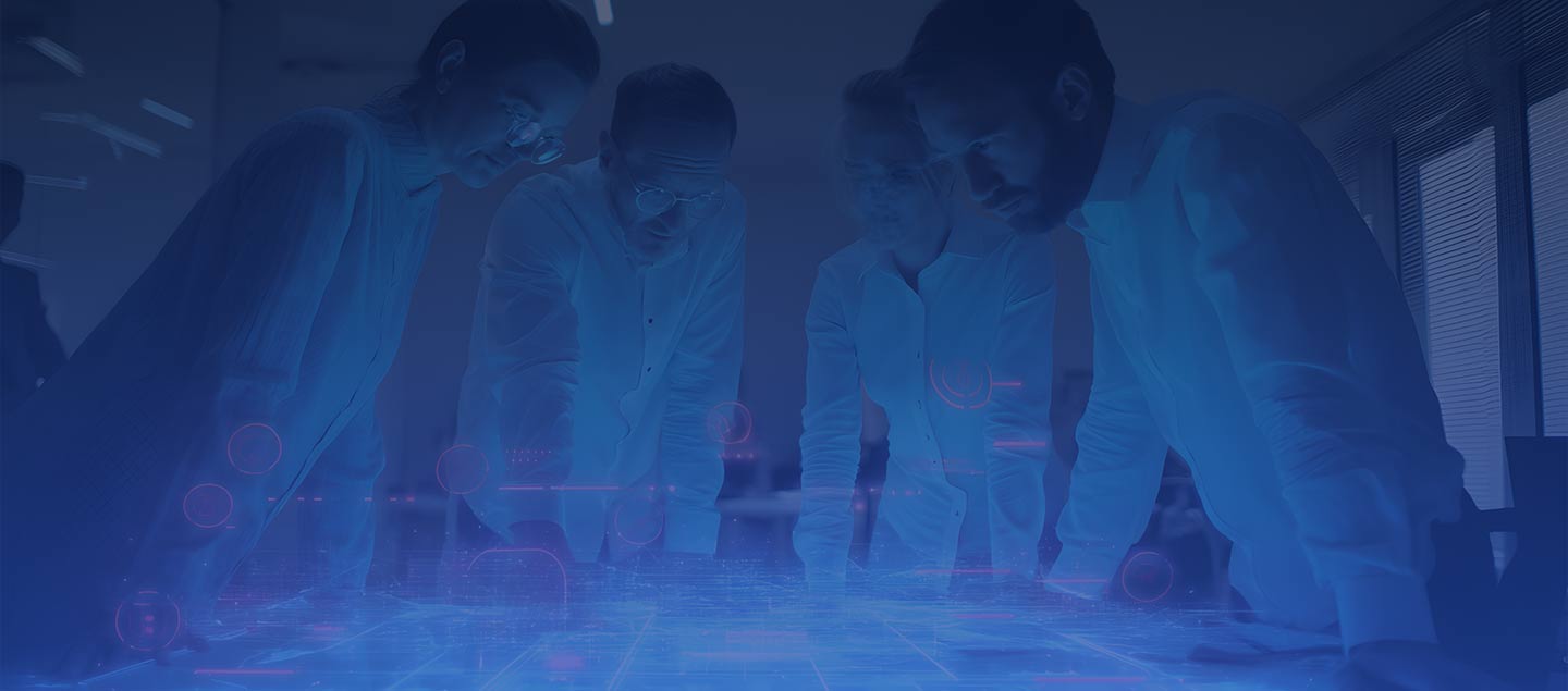 4 people standing over a table with a 3D digital graphic displaying