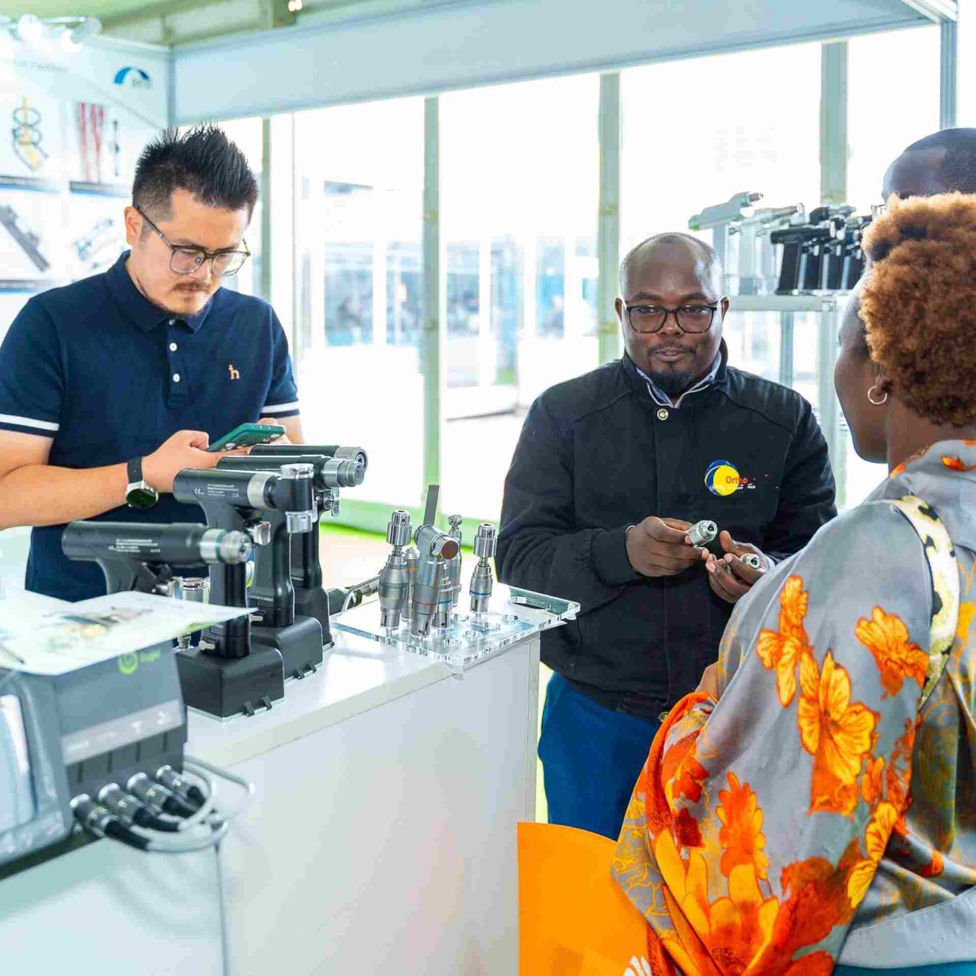 Exhibitors showing a medical device to attendees at World Health Expo Labs Nairobi