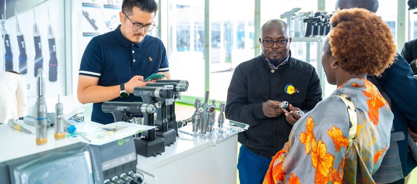 Exhibitors showing a medical device to attendees at World Health Expo Labs Nairobi