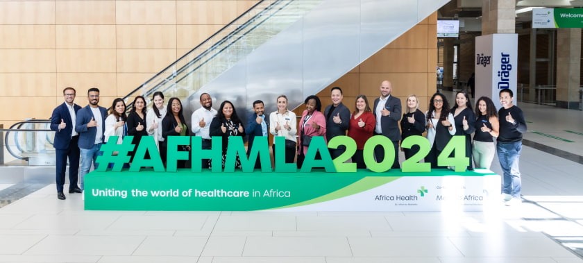 Delegates standing in front of the World Health Expo Cape Town sign.