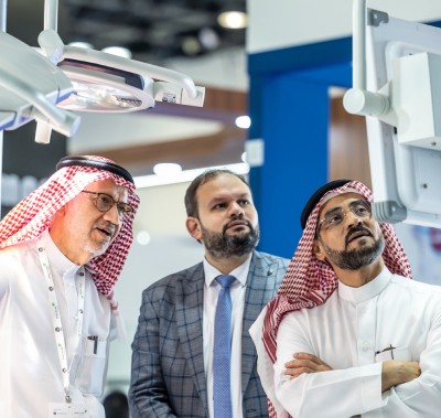 Three men looking at a medical display at WHX Dubai
