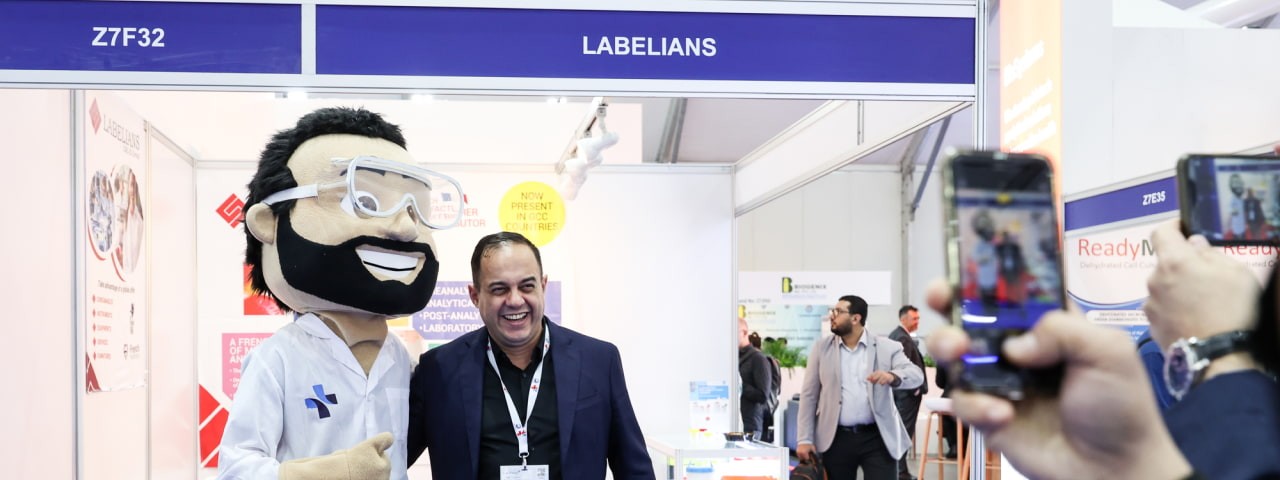 Delegate having his photo taken with the event mascot Mr. Meddy