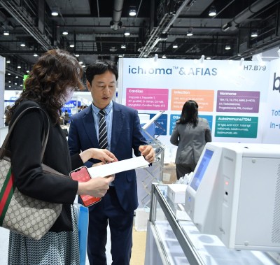 Exhibitor explaining a product at World Health Expo Labs Kuala Lumpur