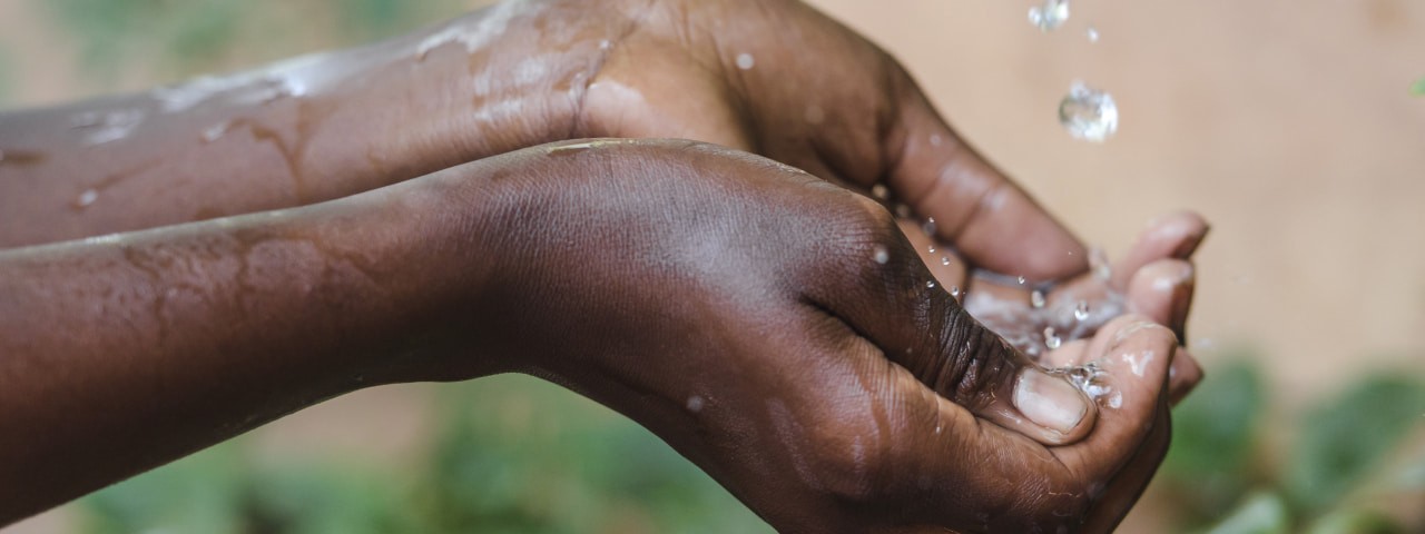 Hands catching water droplets.